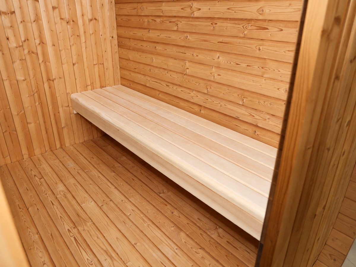 Smalle houten bank langs de wand in de voorruimte van de Passion Cube Luxury 300 Multiroom sauna.