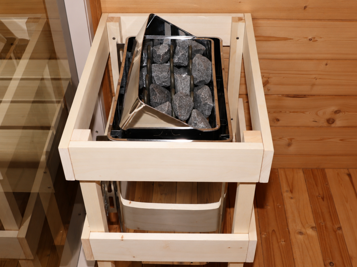 Bovenaanzicht van de saunakachel met stenen en houten beschermrek in de Passion Sauna House Olivin 510.