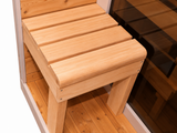 Detail van het houten bankje met brede latten naast de glazen deur van de Passion Sauna House Olivin 230.